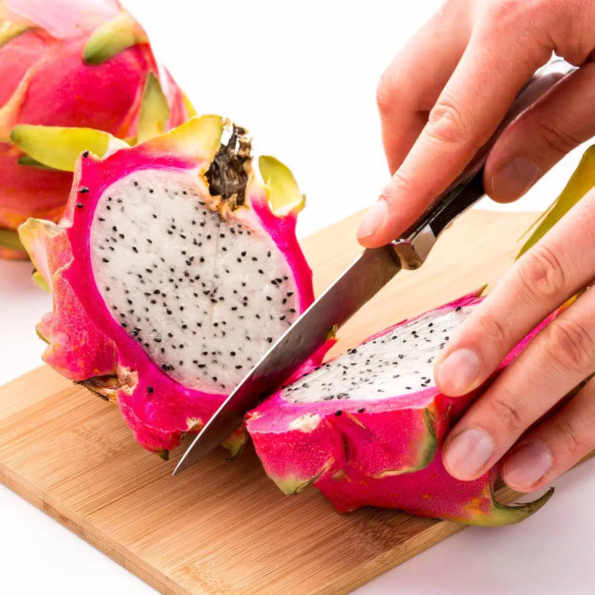 Hand cutting a dragon fruit.