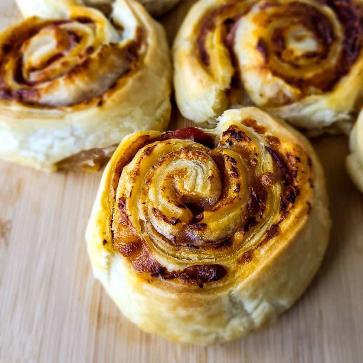 Three pieces of puff pastry pizza rolls.
