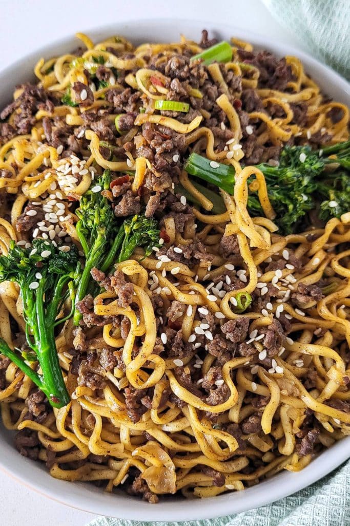 Stir fried ground beef noodles with broccoli and garnished with sesame seeds.