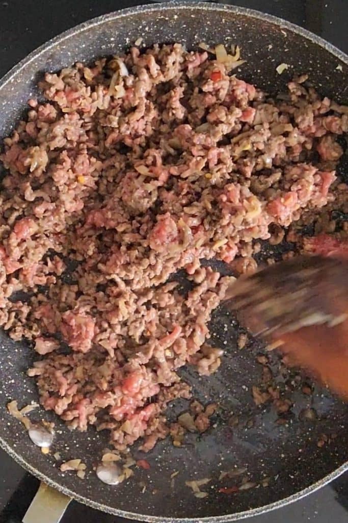 Ground beef with spices on a skillet.