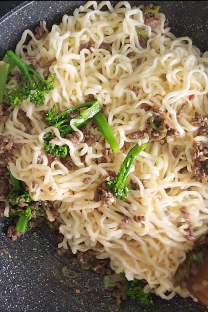 Cooked noodles with ground beef and broccoli.