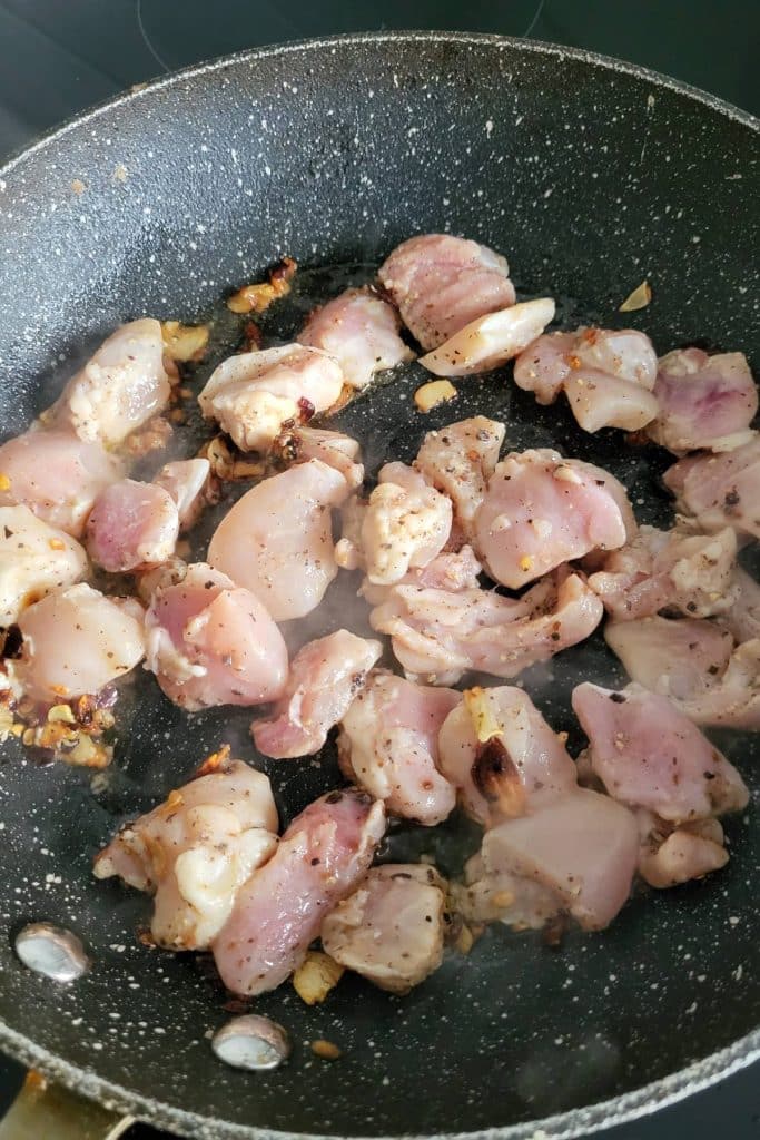 Chicken pieces on a frying pan.