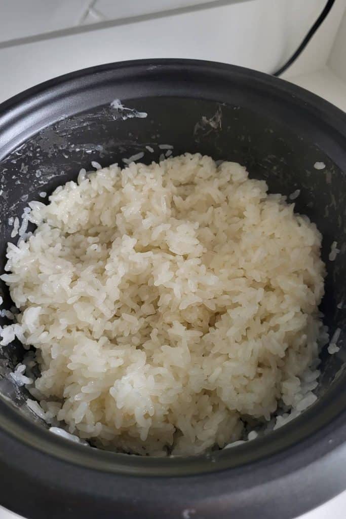 Cooked sticky rice in rice cooker bowl.