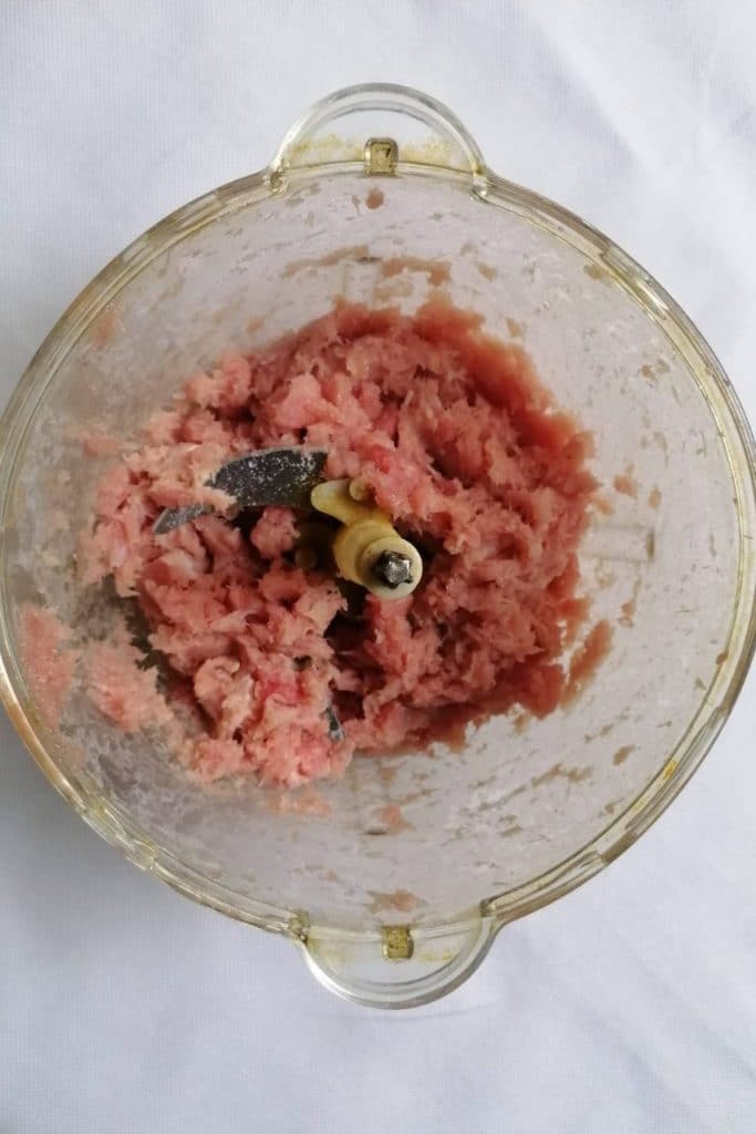 Minced fish and chicken in a food processor bowl.