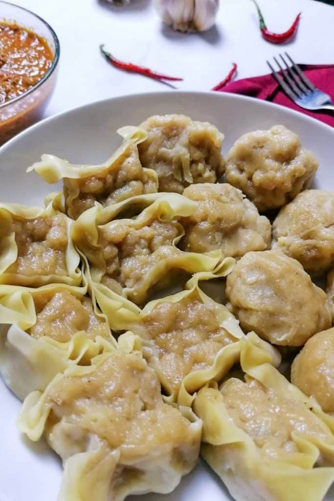 Indonesian Siomay With Peanut Sauce, Chilies, and A Fork in The Background.