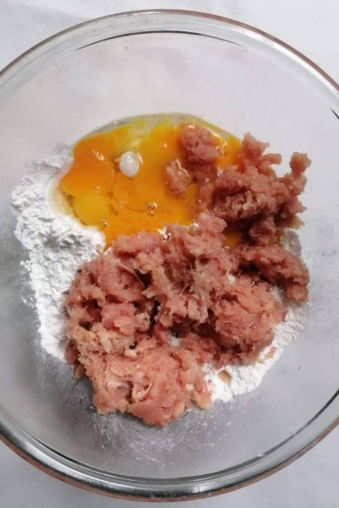Flour, minced fish, egg, and spices in a mixing bowl.