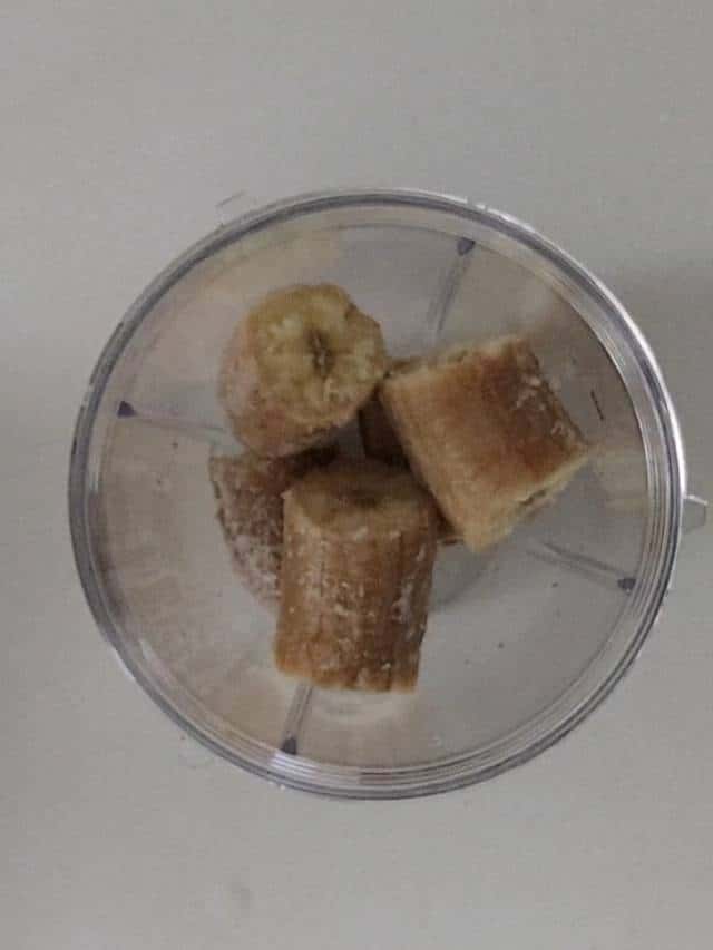 Frozen banana in a blender cup.