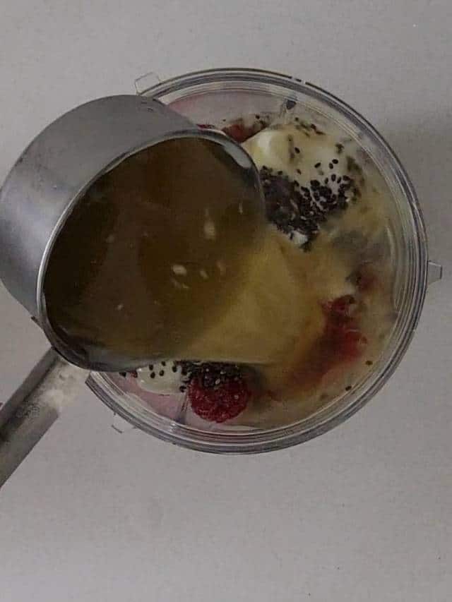 Pouring apple juice into yogurt mixture.