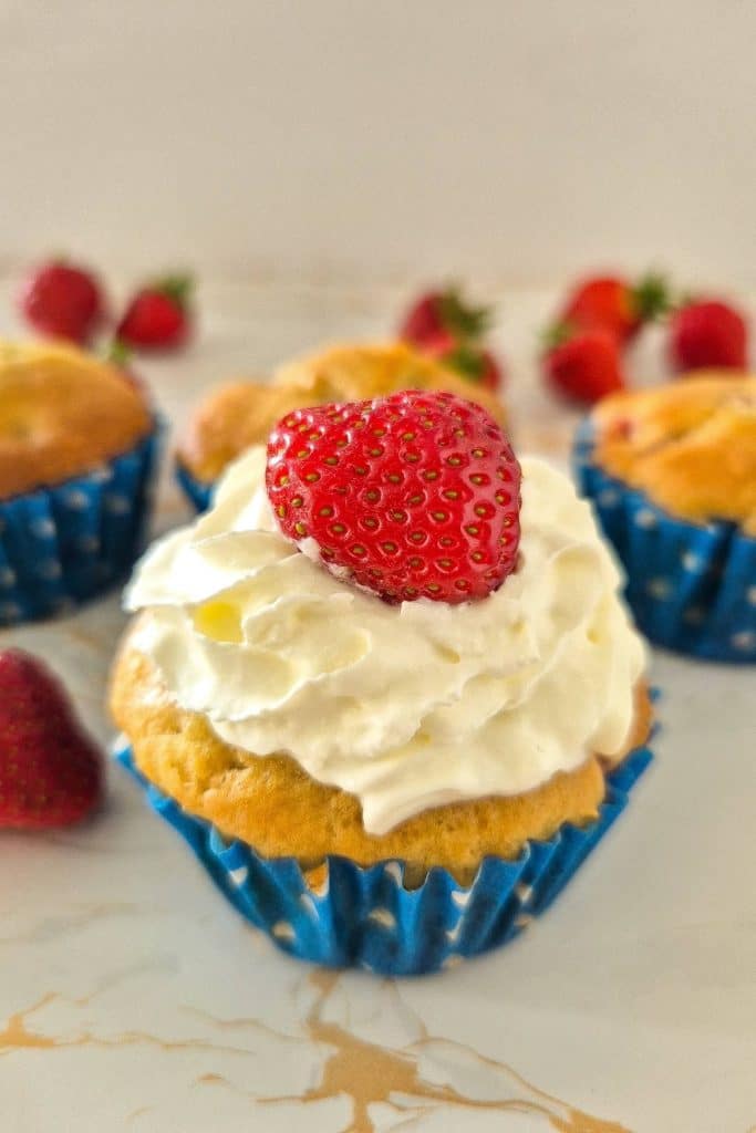 Strawberry muffins with cream and fresh strawberry.