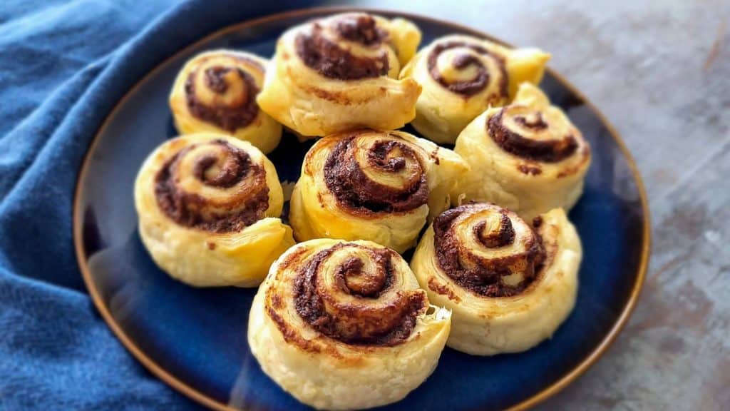 Puff pastry nutella rolls on a blue plate.