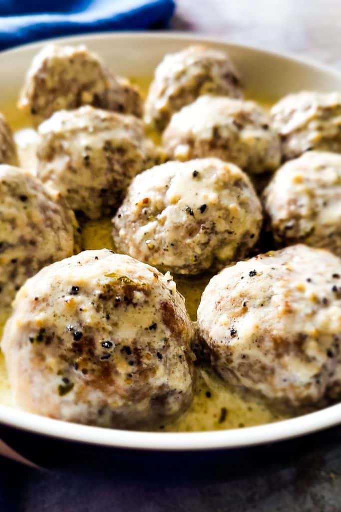 Close-up of beef kofta meatballs coated in creamy pan gravy.