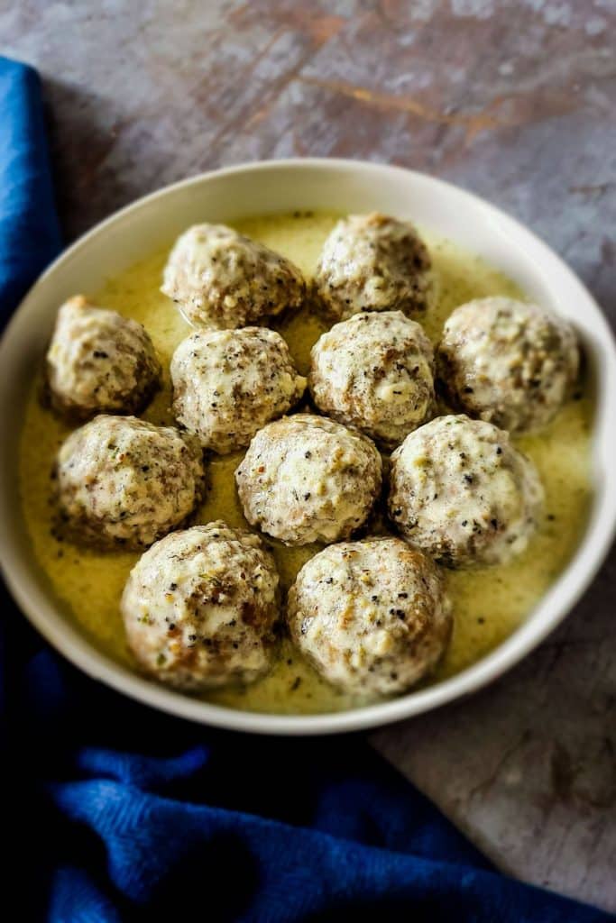 Overhead view of beef kofta meatballs in a pan with creamy gravy.