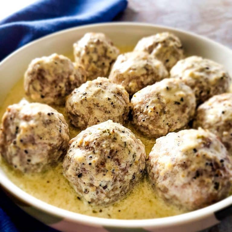 Beef kofta meatballs with creamy sauce on a serving plate.