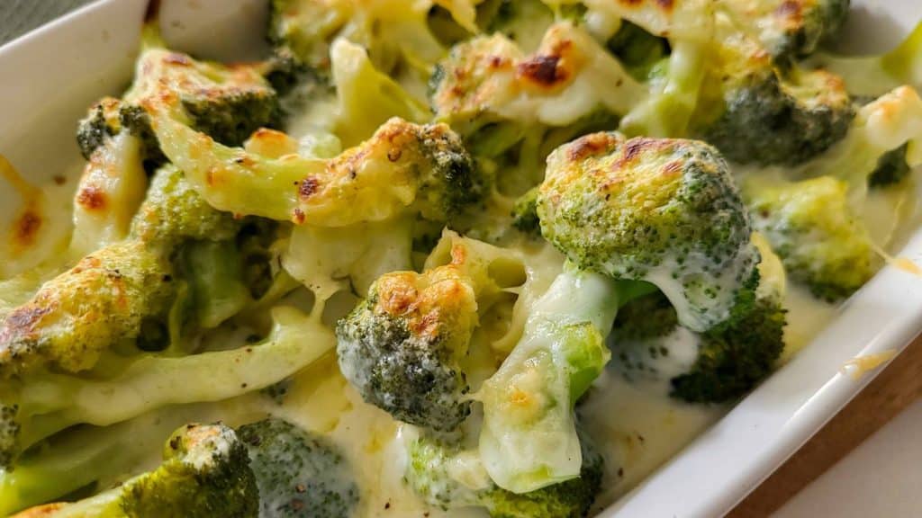Broccoli gratin in a white casserole dish.