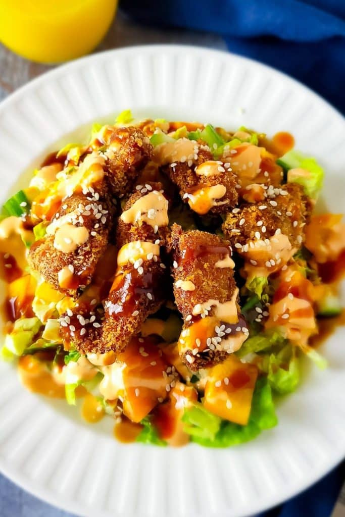 Crispy chicken salad in white bowl.