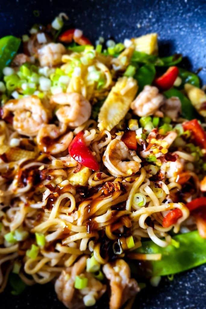 Close-up of shrimp lo mein noodles with extra drizzle of sauce.