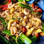 Shrimp lo mein noodles with vegetables in a wok, close-up.