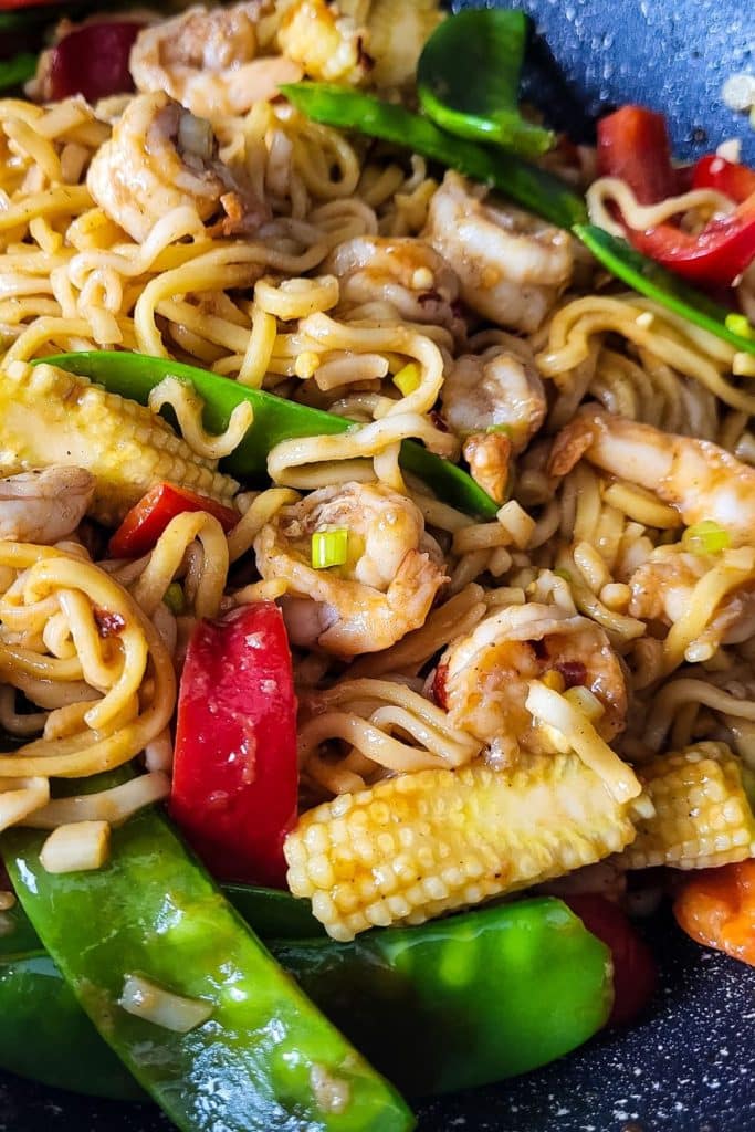 Chinese stir fry egg noodles with shrimp, bell pepper, and snow peas.