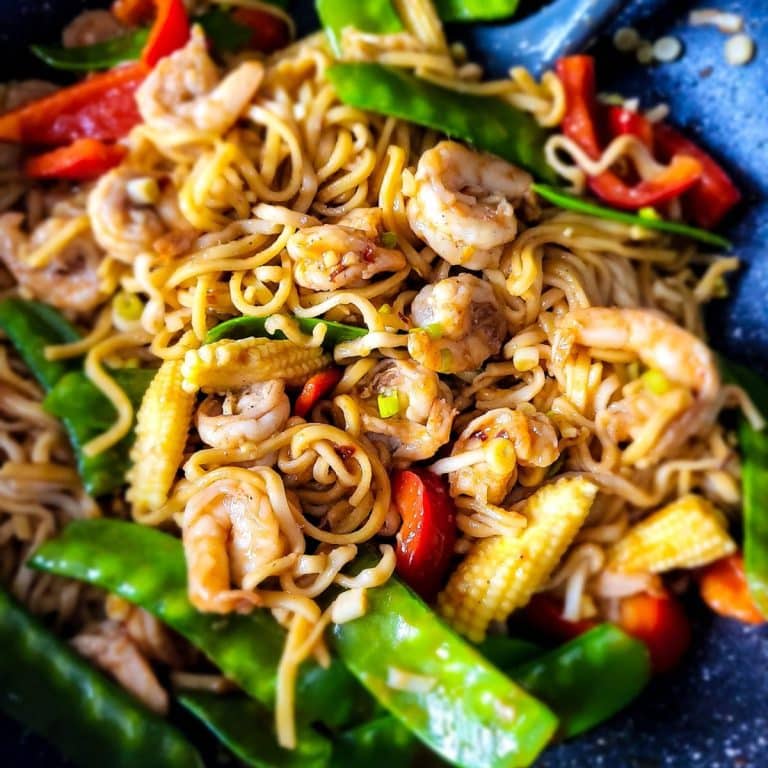 Shrimp lo mein noodles with vegetables in a wok, close-up.