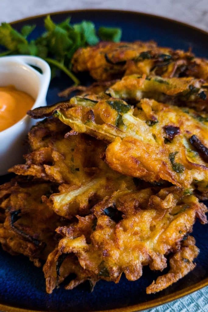Zucchini and sweet potato fritters on a blue plate.