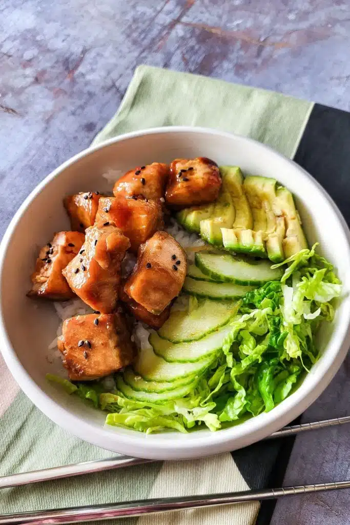 Salmon Teriyaki Bowl with green salad and avocado.